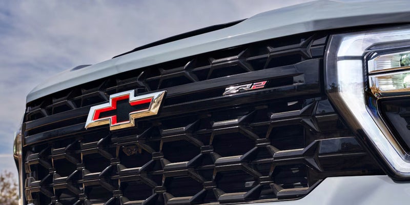 Close-up of the grille of a Chevrolet Silverado truck, showcasing its distinctive design and bold branding.