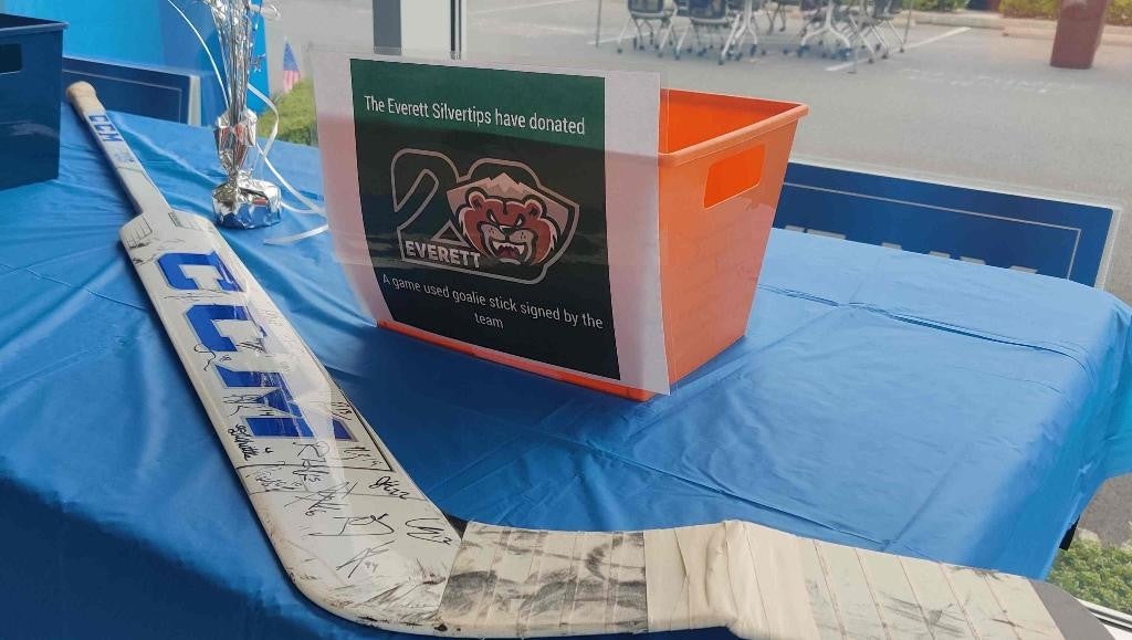 A hockey stick and a sign are positioned on a table, highlighting a sporting event or promotion.